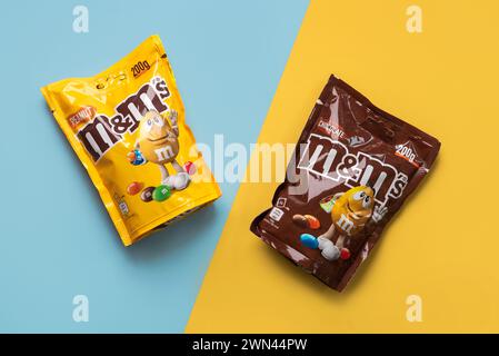 Nahaufnahme von Packungen mit Schokolade und Erdnuss auf blauem und gelbem Hintergrund. Illustrativer Leitartikel Stockfoto