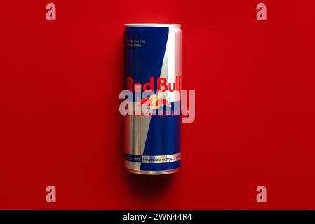 Dose Red Bull Energy Drink auf rotem Hintergrund. Illustrativer Leitartikel Stockfoto