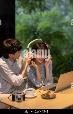 Ein junges Paar, das im Café einen Laptop benutzt Stockfoto