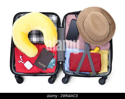 Weiches Reisekissen, Hut, Pässe und andere Gegenstände in offenem Koffer isoliert auf weiß, Blick von oben Stockfoto