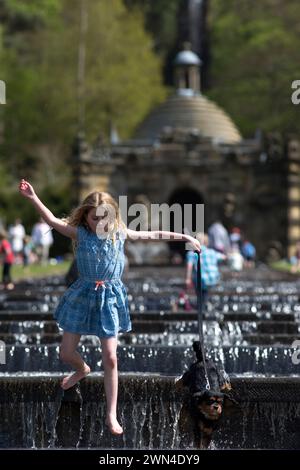 05/15 Isabella Coleman (9) und ihr Kavalier King Charles, Emily, kühlen sich in der Kaskade ab, während die Menschen strömen, um das Wetter am Montag der Bank zu genießen Stockfoto