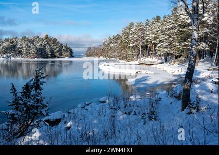 Sonnenlicht über gefrorenem Schwimmbereich im See Vattern Motala Schweden Stockfoto