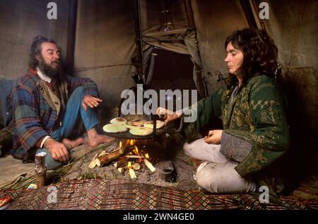 Hippie Counterculture Community 1980s UK. TIPI Valley umweltfreundliche walisische Gruppe von New Age Hippies. Hippie-Paar John Silvani und Crazy Crow Yvonne Maya leben vom Gitter, wie sie in ihrem Tepee über offenem Feuer kochen. Llandeilo, Wales 1985 HOMER SYKES Stockfoto