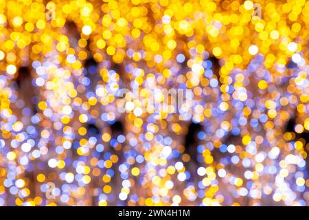 Glänzend goldenes Bokeh beleuchtet abstrakten festlichen Hintergrund mit glänzender Glitzerstruktur und heller glitzernder Beleuchtung Stockfoto