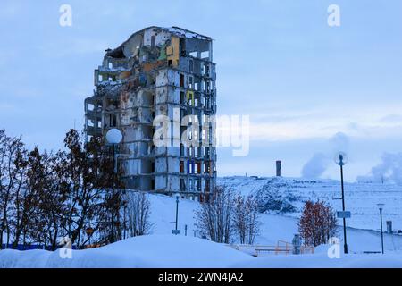 Ein teilweise abgerissener Turmblock in der Altstadt von kiruna vor dem schneebedeckten Eisenerzbergwerk ist Teil der Umsiedlung der Stadt Stockfoto