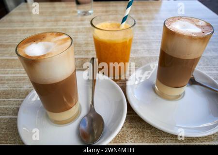 Zwei Cafés Leche Leche oder Café con leche y leche und Orangensaft in einem Café in Corralejo, fuerteventura, Kanarischen Inseln, spanien Stockfoto