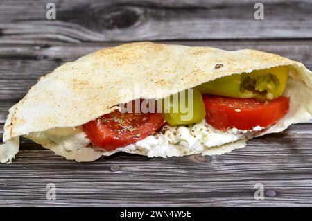 Traditionelles Shami-Fladenbrot aus Weizen und Mehl, gefüllt mit weißem Rahmkäse, Tomatenscheiben, grünen Chilischoten und Thymian her Stockfoto