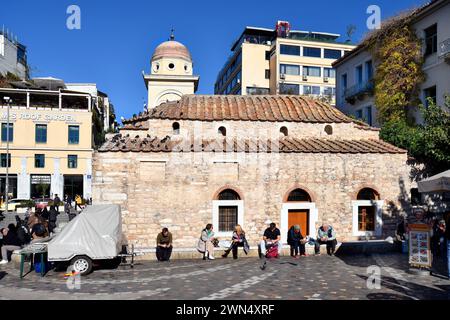 Athen, Griechenland - 19. Dezember 2023: Unbekannte Menschen auf dem Monastiraki-Platz mit der kleinen byzantinischen Kirche, die früher als Panagia Pantanasa the Ath bekannt war Stockfoto