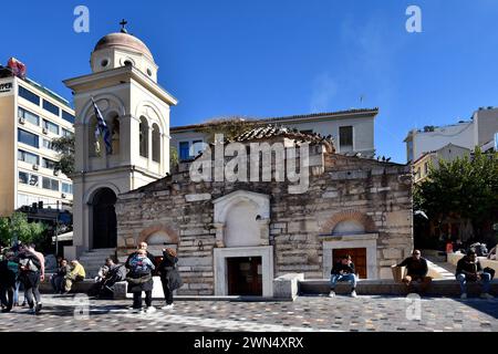 Athen, Griechenland - 19. Dezember 2023: Unbekannte Menschen auf dem Monastiraki-Platz mit der kleinen byzantinischen Kirche, die früher als Panagia Pantanasa the Ath bekannt war Stockfoto