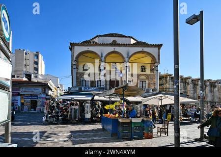 Athen, Griechenland - 19. Dezember 2023: Nicht identifizierte Menschen auf dem Monastiraki-Platz mit der Tzisdaraki-Moschee - heute als Museum für moderne griechische Kultur genutzt Stockfoto