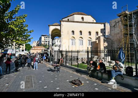 Athen, Griechenland - 19. Dezember 2023: Nicht identifizierte Menschen und Straßenmusiker auf dem Monastiraki-Platz mit der kleinen byzantinischen Kirche, die früher Pana genannt wurde Stockfoto