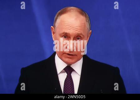 St. Petersburg, Russland. Februar 2024. Der russische Präsident Wladimir Putin spricht vor der Bundesversammlung in einer Live-Übertragung in einem Kino in St. Petersburg. Quelle: SOPA Images Limited/Alamy Live News Stockfoto