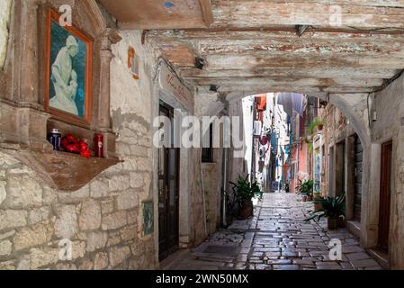 Schmaler Bogengang zwischen historischen Gebäuden mit einer kleinen Kapelle in der Altstadt von Rovinj. Rovigno, Istrien, Kroatien 2019 Stockfoto