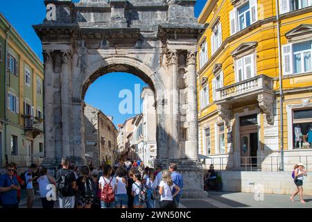 Touristen unter dem Sergio Arch - römischer Triumphbogen der Familie Sergio, der 29 v. Chr. zum Gedenken an Mitglieder der Familie Sergio erbaut wurde. Pula, Pola, Istrien, Kroatien. Stockfoto