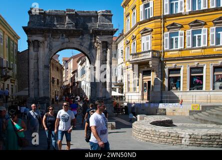 Touristen unter dem Sergio Arch - römischer Triumphbogen der Familie Sergio, der 29 v. Chr. zum Gedenken an Mitglieder der Familie Sergio erbaut wurde. Pula, Pola, Istrien, Kroatien. Stockfoto