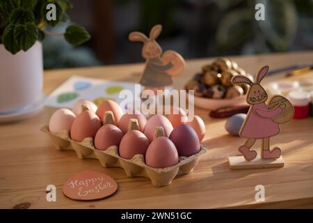 Keine Leute Nahaufnahme von farbigen Eiern und Kaninchenfiguren auf dem Tisch, Osterstilleben-Komposition Stockfoto