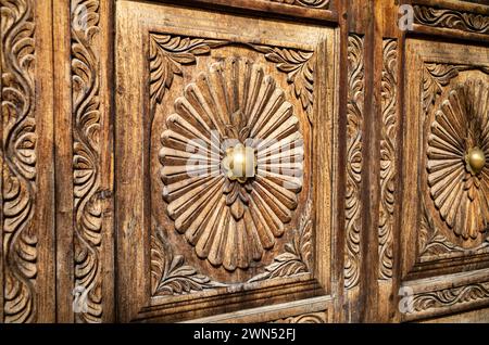 Nahaufnahme einer traditionellen kunstvoll geschnitzten Holztür mit Messingdekorationen in Stone Town, Sansibar, Tansania Stockfoto