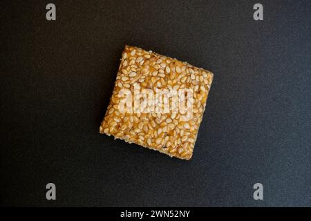 Bis Chikki auf schwarzgrauem Hintergrund. Till Chikki ist ein indisches Süßwarengericht, das mit Jaggery und Sesam zubereitet wird. Indisches Festival makar sankranti besonderes Süßes Stockfoto