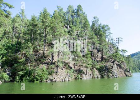 Der malerische Blick auf den grünen Karacaoren See und die steile Küste mit wachsenden Bäumen (Provinz Antalya, Türkei). Stockfoto