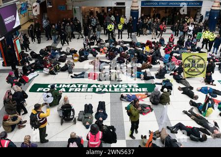 London, Großbritannien. 29. Februar 2024. Aktivisten aus einer Koalition, darunter Extinction Rebellion, StopEACOP, war on Want und Global Justice, inszenieren jetzt einen Protest "Klimaaktivisten für ein freies Palästina", indem sie kurz in Solidarität mit dem Volk von Gaza einen Todesfall an der Liverpool Street Station durchführen. Quelle: Ron Fassbender/Alamy Live News Stockfoto