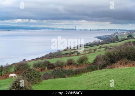 Ein Blick über Felder zurück entlang der Severn River Mündung von Clevedon in Richtung der Prince of Wales Bridge, die von England nach Wales überquert wird Stockfoto