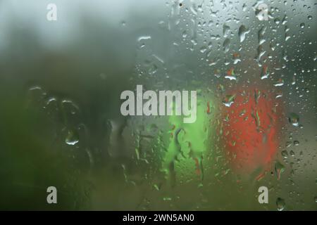 Regen tropft auf der Glasoberfläche mit bewölktem Hintergrund. Natürliches Muster von Regentropfen auf bewölktem Hintergrund. Unscharfer Kopierbereich. Traurige Stimmung. Aus f Stockfoto