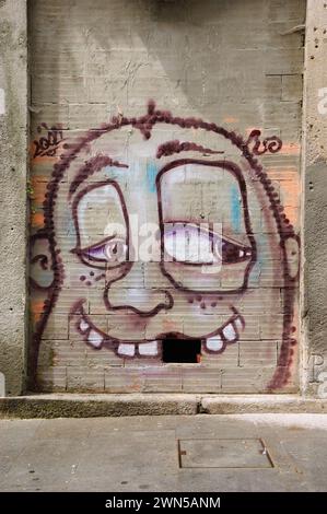 Porto, Portugal - 26. April 2015: Street Art. Lustiges Gesicht mit fehlendem Zahn (fehlender Ziegel in der Wand). Graffiti des Künstlers Costah Stockfoto