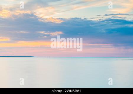 Eine riesige Wasserfläche, wahrscheinlich ein See, erstreckt sich unter einem Himmel voller dicker, dunkler Wolken. Die Szene deutet auf einen drohenden Sturm oder eine Bewölkung hin Stockfoto