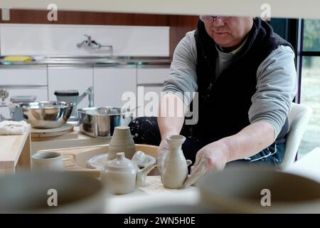 Namie, Fukushima, Japan. Februar 2024. Ein Töpfer macht Tonkeramik in der Werkstatt Toukichirougama im Obori-Bezirk Namie Town. Das Kernkraftwerk Fukushima Daiichi erlebte eine nukleare Katastrophe, die zur Evakuierung tausender Einwohner führte, nachdem das große Erdbeben in Ostjapan und der anschließende Tsunami die Präfekturen Miyagi, Iwate und Fukushima verwüstet hatten. Ein Jahrzehnt nach der Aufhebung des Evakuierungsbefehls des Bezirks Miyakoji in Tamura City war das erste Gebiet, in dem Beschränkungen aus einem Radius von 20 Kilometern des Kernkraftwerks von TEPCO in Fukushima aufgehoben wurden Stockfoto