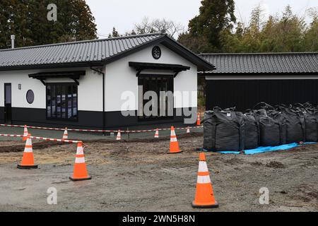 Namie, Fukushima, Japan. Februar 2024. Schwarze Säcke mit kontaminiertem Boden sind vor der Toukichirougama-Werkstatt im Obori-Bezirk Namie-Stadt zu sehen. Das Kernkraftwerk Fukushima Daiichi erlebte eine nukleare Katastrophe, die zur Evakuierung tausender Einwohner führte, nachdem das große Erdbeben in Ostjapan und der anschließende Tsunami die Präfekturen Miyagi, Iwate und Fukushima verwüstet hatten. Ein Jahrzehnt nach der Aufhebung des Evakuierungsbefehls des Bezirks Miyakoji in Tamura City war das erste Gebiet, in dem Beschränkungen aus einem Radius von 20 Kilometern der Kernenergie von TEPCO aufgehoben wurden Stockfoto