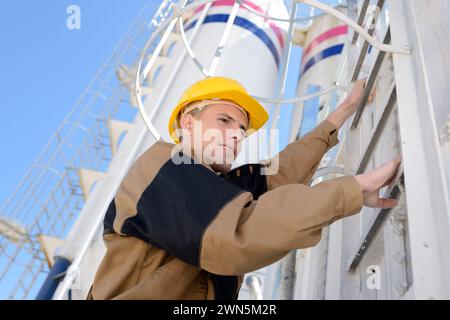 Ein Arbeiter klettert auf eine Leiter Stockfoto