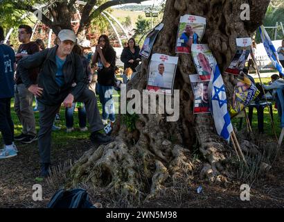 Beit Guvrin, Israel. Februar 2024. Ein israelischer Marscher in der Nähe eines Olivenbaums mit Plakaten, die Israelis als Geisel gehalten haben, während sich die Marschierenden am 29. Februar 2024 in Beit Guvrin, Zentralisrael, versammeln, um einen weiteren Tag des Marschens von den Gemeinden des Gazastreifens nach Jerusalem zu beenden. Etwa 500 Demonstranten und Familienangehörige von Geiseln, die im Gazastreifen festgehalten wurden, marschieren nach Jerusalem und rufen die Regierung auf, sie nach Hause zu bringen, da sie von Hamas-Terroristen während ihrer mörderischen Ausschreitungen am 7. Oktober 2024 als Geiseln gefangen genommen wurden. Foto von Jim Hollander/UPI Credit: UPI/Alamy Live News Stockfoto