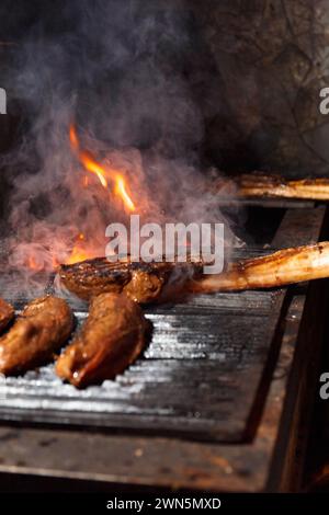 Appetitliche saftige Tomahawk-Steaks, Ribeye und Lendensteaks auf einem Grill über brennender Flamme beim Grillen. Gegrilltes Fleisch in einem Restaurant. Stockfoto