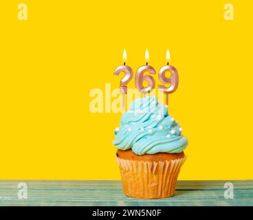 Geburtstagskuchen Mit Kerze Fragezeichen Und Nummer 69 - Auf Gelbem Hintergrund. Stockfoto