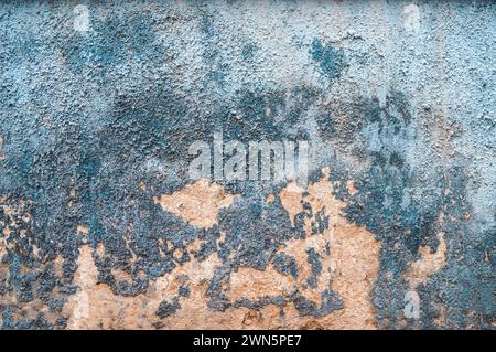 Alte zerrissene, verwitterte, gemalte Hintergrundstruktur der Wand. Schmutzige, abgeschälte Putzwand mit abfallenden Farbflecken. Abstraktes Schleifen unebener Oberfläche mit Stockfoto