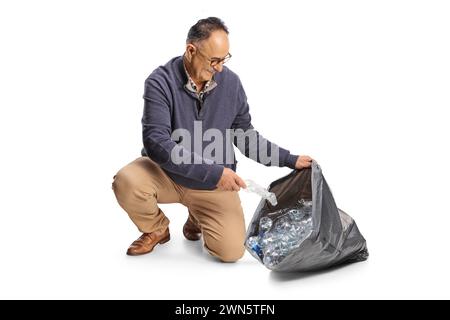 Reifer Mann sammelt Plastikflaschen in einem schwarzen Müllsack isoliert auf weißem Hintergrund Stockfoto