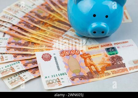 Schweinebank und russische Banknoten auf grauem Hintergrund. Der Begriff der Akkumulation und Speicherung von Geld. Stockfoto