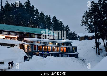 Gulmarg, Kaschmir, Indien. Februar 2024. Besucher spazieren durch eine schneebedeckte Straße während eines kalten Abends im Skigebiet Gulmarg, etwa 55 km von Srinagar, der Sommerhauptstadt Jammu und Kaschmir entfernt. (Credit Image: © Saqib Majeed/SOPA Images via ZUMA Press Wire) NUR REDAKTIONELLE VERWENDUNG! Nicht für kommerzielle ZWECKE! Stockfoto