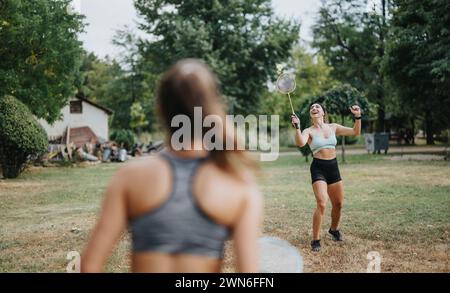 Attraktive Athleten spielen Badminton in einem Sunny Park mit Freunden Stockfoto