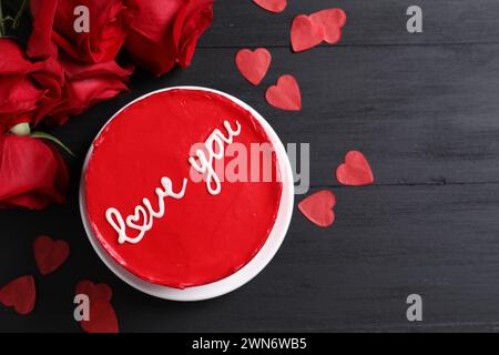 Bento Torte mit Text Love You, Rosen, Papierherzen und Platz für Text auf schwarzem Holztisch, flach gelegt. St. Valentinstag-Überraschung Stockfoto