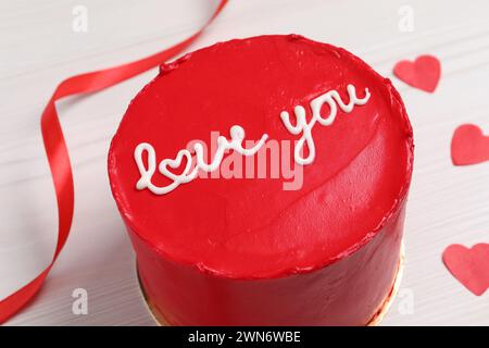 Bento Kuchen mit Text Love You und Papierherzen auf weißem Holztisch, Nahaufnahme. St. Valentinstag-Überraschung Stockfoto
