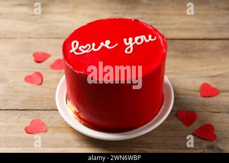 Bento Kuchen mit Text Love You und Papierherzen auf Holztisch. St. Valentinstag-Überraschung Stockfoto