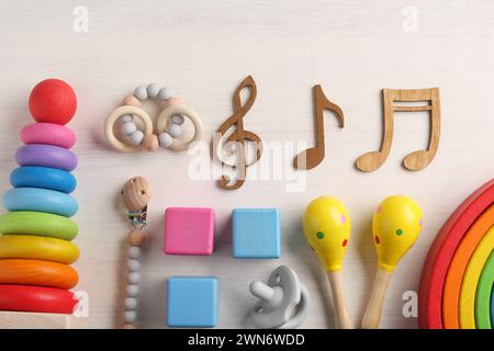 Baby-Lied-Konzept. Hölzerne Notizen, Maracas für Kinder und Spielzeug auf dem Tisch, flache Lagen Stockfoto