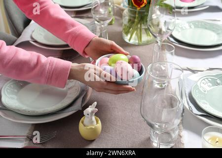 Frau, die zu Hause einen Tisch für festliches Osteressen legt, Nahaufnahme Stockfoto