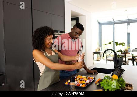 Ein birassisches afroamerikanisches Paar kocht zusammen in einer modernen Küche zu Hause Stockfoto