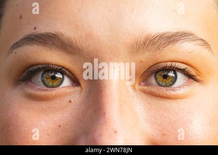 Nahaufnahme der Augen einer jungen kaukasischen Frau auf einer Wanderung, mit Haselnussblumen Stockfoto