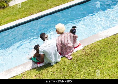 Die afroamerikanische Familie genießt einen sonnigen Tag im Freien mit den Füßen im Wasser Stockfoto