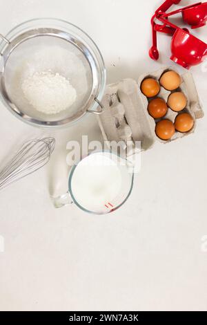 Die Zutaten zum Backen sind auf einer weißen Oberfläche mit Kopierraum ordentlich angeordnet Stockfoto