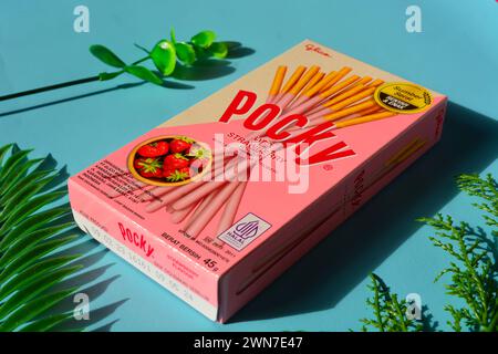 Wonosobo, Indonesien 23. April 2023: Pocky Snacks mit Erdbeergeschmack in rosa Verpackung. Vor blauem Hintergrund. Stockfoto