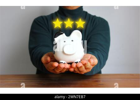 Asiatischer Mann mit Schweinebank mit Illustrationsstern, Sparkonzept Stockfoto